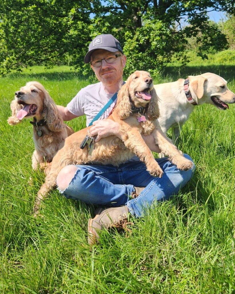Nick, dog walker at Premier Dog Walkers, with two cocker spaniels and a Labrador